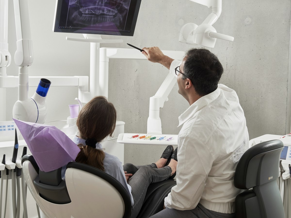 Dentist reviewing an x-ray with a patient - dental missed call text back service